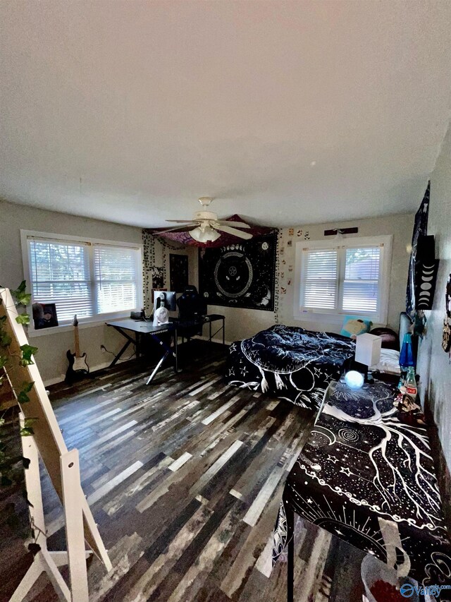 bedroom with hardwood / wood-style flooring, multiple windows, and ceiling fan