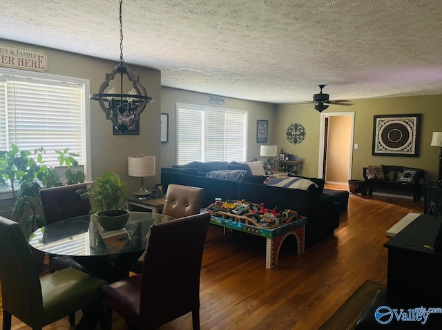 dining area featuring wood-type flooring, ceiling fan, and a textured ceiling