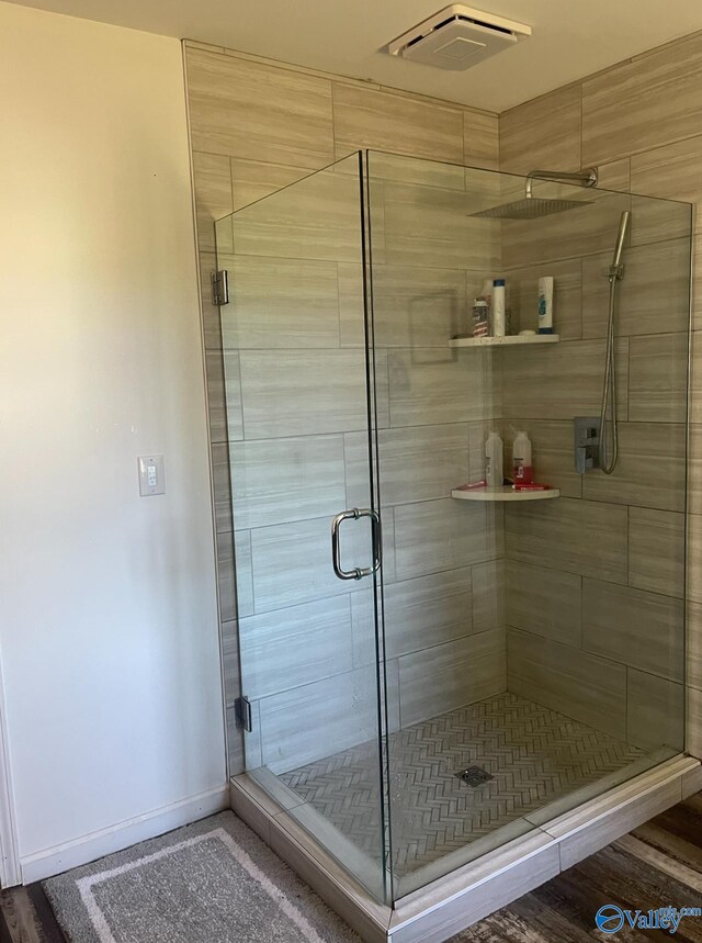 bathroom featuring walk in shower and hardwood / wood-style floors