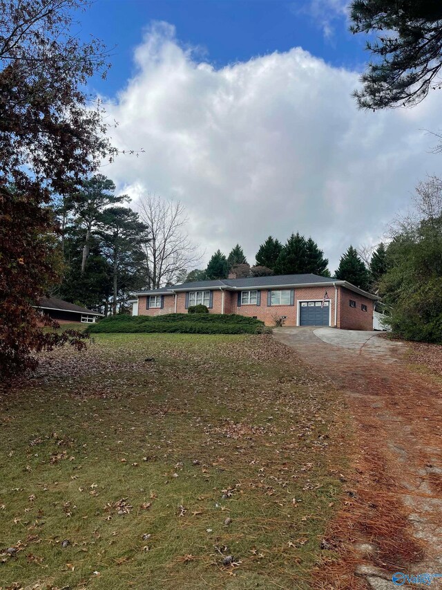 ranch-style home with a garage and a front lawn