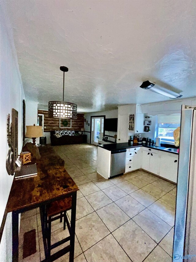 kitchen with a wealth of natural light, white cabinetry, pendant lighting, and appliances with stainless steel finishes