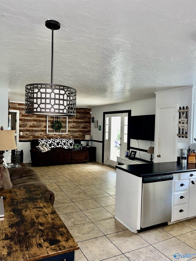 kitchen featuring stainless steel dishwasher, a textured ceiling, light tile patterned floors, and white cabinets