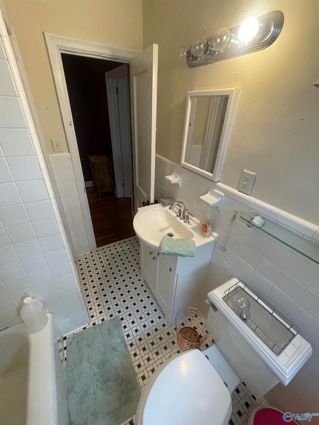 bathroom with tile patterned floors, vanity, toilet, and tile walls