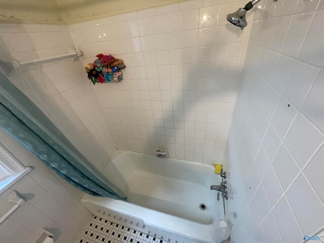 bathroom featuring tile patterned floors and shower / bath combo with shower curtain