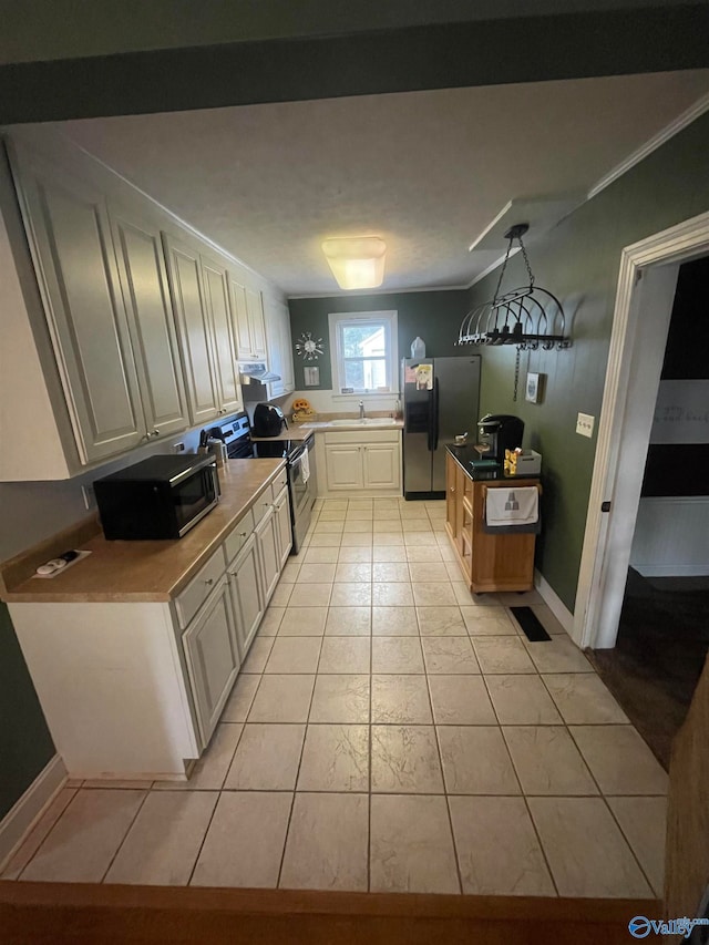 kitchen featuring appliances with stainless steel finishes, crown molding, sink, light tile patterned floors, and decorative light fixtures