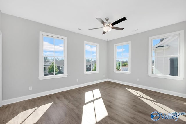 spare room featuring dark wood-type flooring and ceiling fan