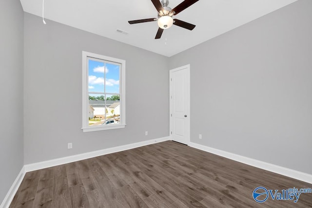 spare room featuring dark wood-type flooring and ceiling fan