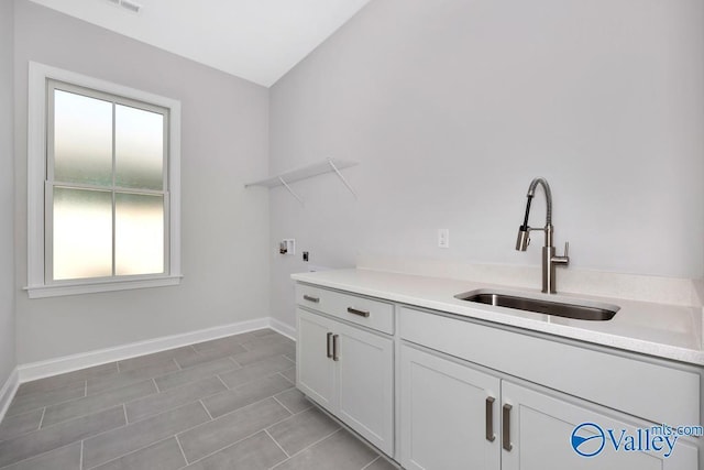 laundry area with cabinets, washer hookup, and sink