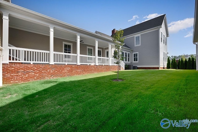 rear view of house featuring a yard and covered porch