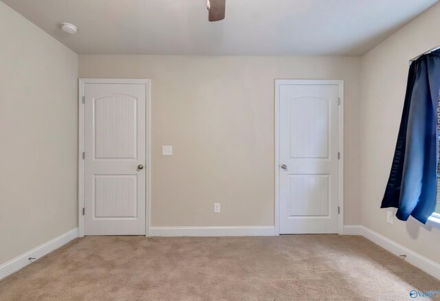 spare room with carpet flooring, a tray ceiling, and ceiling fan