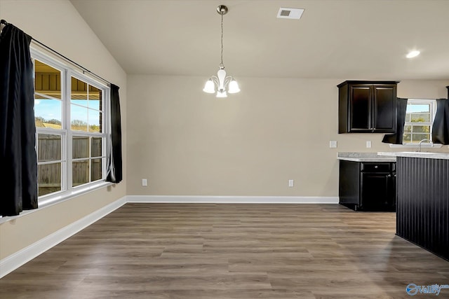 kitchen featuring wood-type flooring, an inviting chandelier, sink, and plenty of natural light