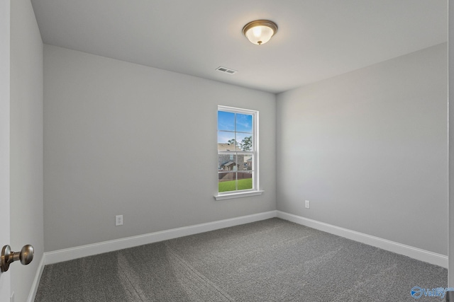 carpeted spare room with visible vents and baseboards