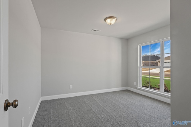 carpeted empty room with visible vents and baseboards