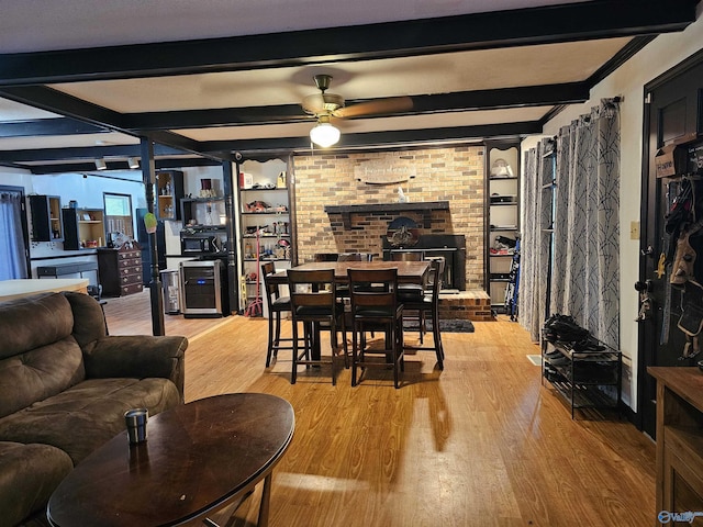 dining area with beamed ceiling, hardwood / wood-style floors, beverage cooler, and ceiling fan