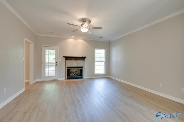 unfurnished living room with a tile fireplace, light wood-type flooring, and crown molding