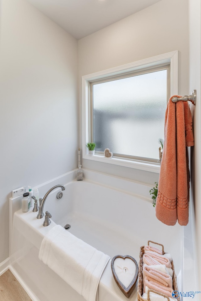 bathroom with a wealth of natural light and a tub