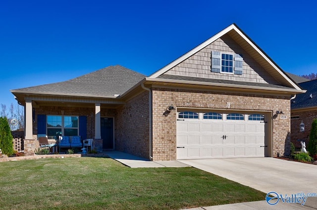 view of front of home featuring a garage, covered porch, and a front lawn