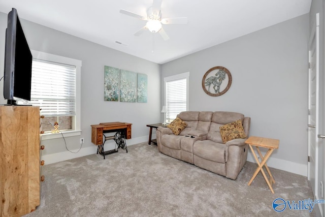 living room with light colored carpet, ceiling fan, and a healthy amount of sunlight