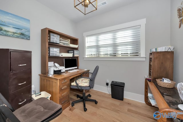 office space featuring a notable chandelier and light wood-type flooring