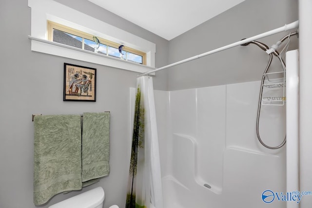 bathroom with a shower with curtain and toilet