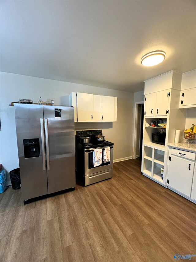 kitchen with hardwood / wood-style flooring, stainless steel appliances, and white cabinetry