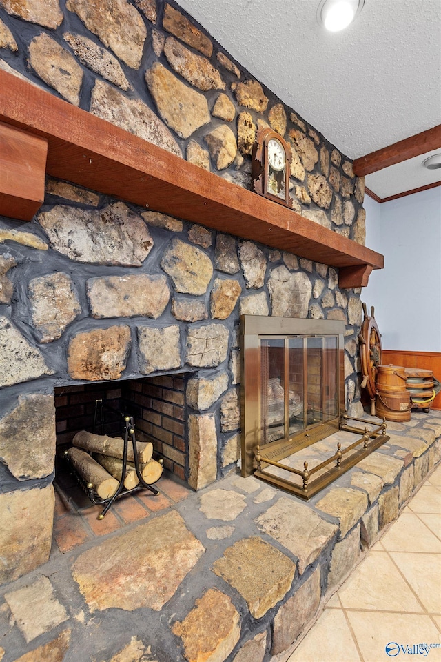 details featuring beamed ceiling, a fireplace, a wainscoted wall, and a textured ceiling