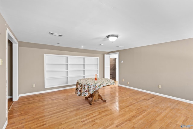 interior space featuring light wood-type flooring, baseboards, and visible vents