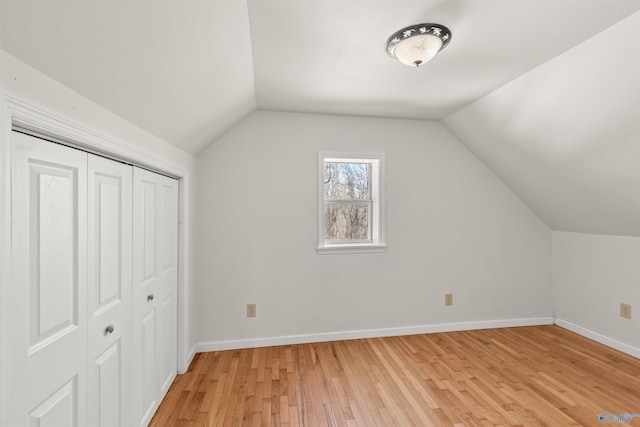 bonus room with baseboards, vaulted ceiling, and light wood finished floors