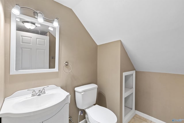 bathroom with baseboards, lofted ceiling, toilet, and vanity