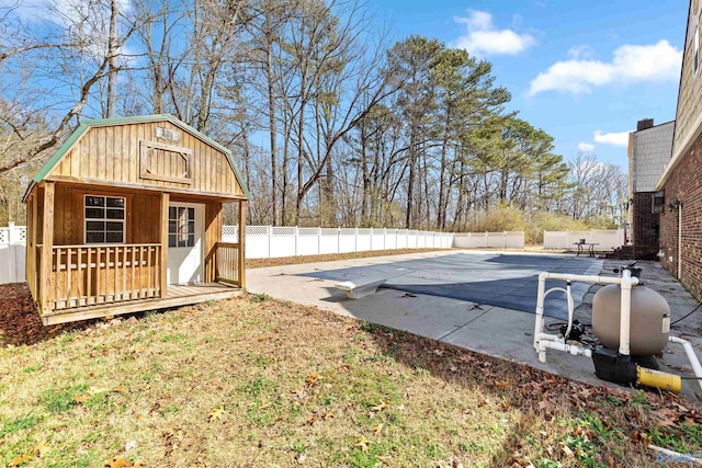 view of yard with an outdoor structure, a fenced backyard, a fenced in pool, and a patio
