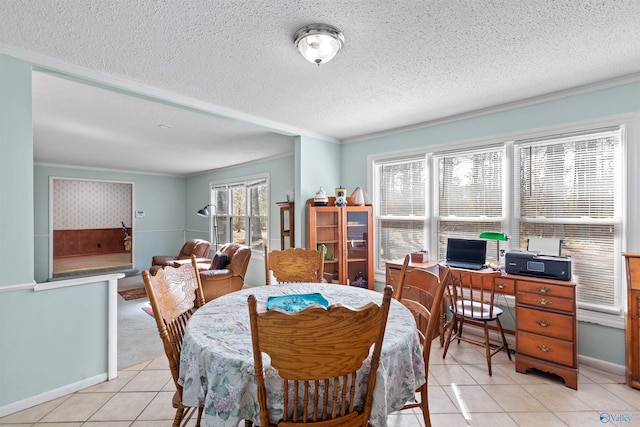 dining space featuring light tile patterned flooring, a textured ceiling, baseboards, and ornamental molding