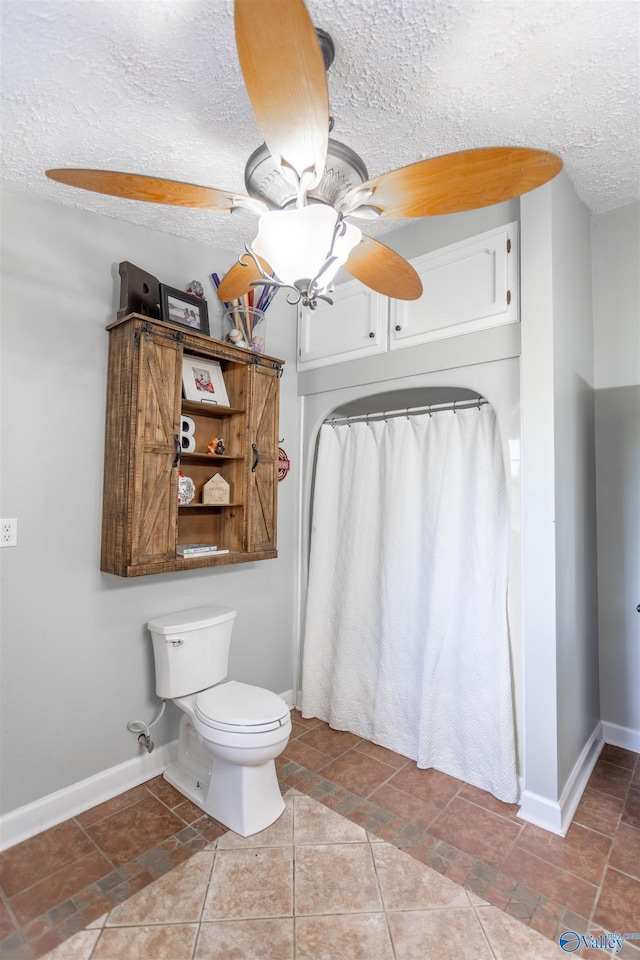 bathroom featuring tile patterned flooring, ceiling fan, toilet, and a textured ceiling