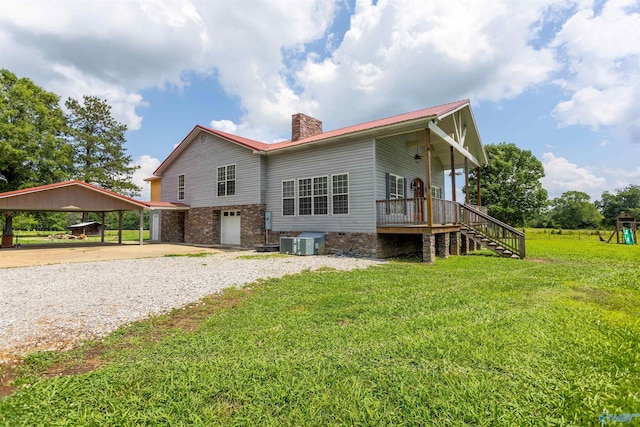 back of house featuring a garage, a carport, cooling unit, and a lawn