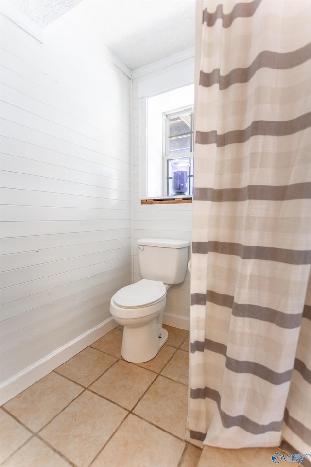 bathroom with crown molding, tile patterned floors, and toilet