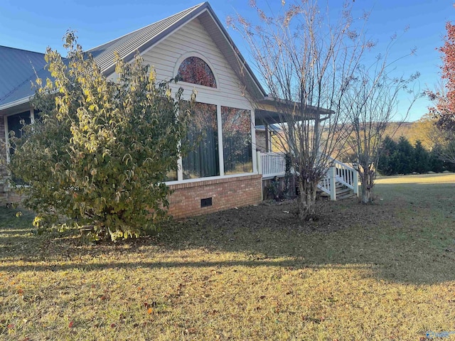 view of side of home with a lawn and a sunroom