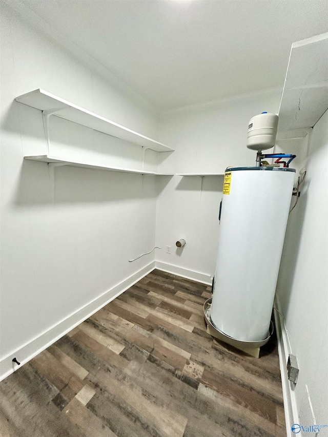 laundry room featuring water heater, dark wood-type flooring, and hookup for a washing machine