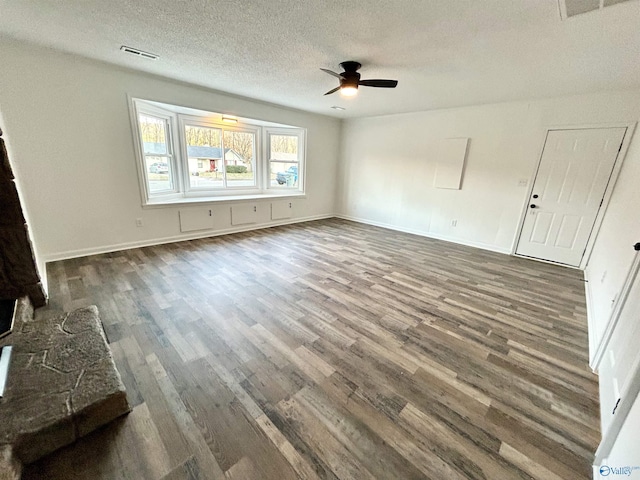 unfurnished living room with ceiling fan, a textured ceiling, and dark hardwood / wood-style floors