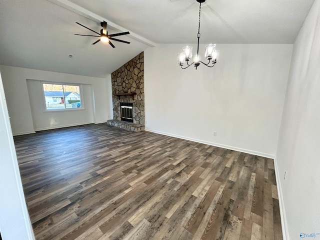 unfurnished living room featuring ceiling fan with notable chandelier, dark hardwood / wood-style flooring, a fireplace, and lofted ceiling with beams