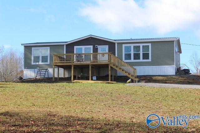 back of property with a deck and a lawn