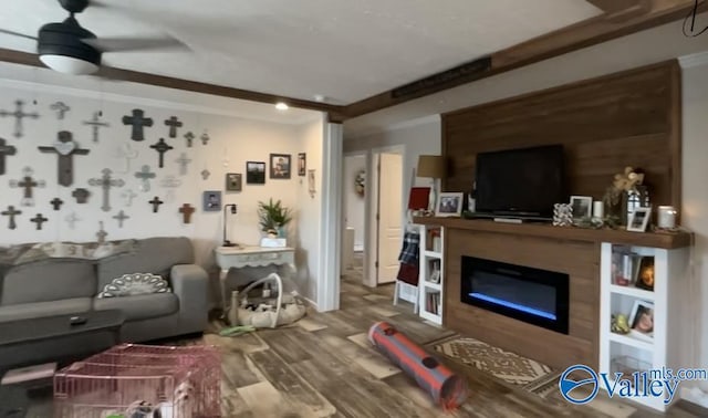 living room featuring ceiling fan, crown molding, and wood-type flooring