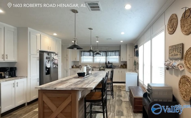 kitchen featuring white cabinetry, stainless steel fridge with ice dispenser, and a healthy amount of sunlight