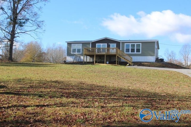 view of front facade with a wooden deck and a front lawn