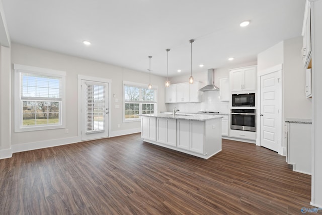 kitchen with white cabinets, wall chimney exhaust hood, hanging light fixtures, stainless steel oven, and black microwave