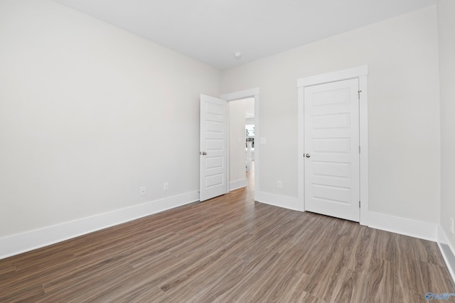 unfurnished bedroom with wood finished floors and baseboards