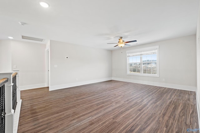 unfurnished living room featuring dark wood-type flooring, a ceiling fan, visible vents, and baseboards