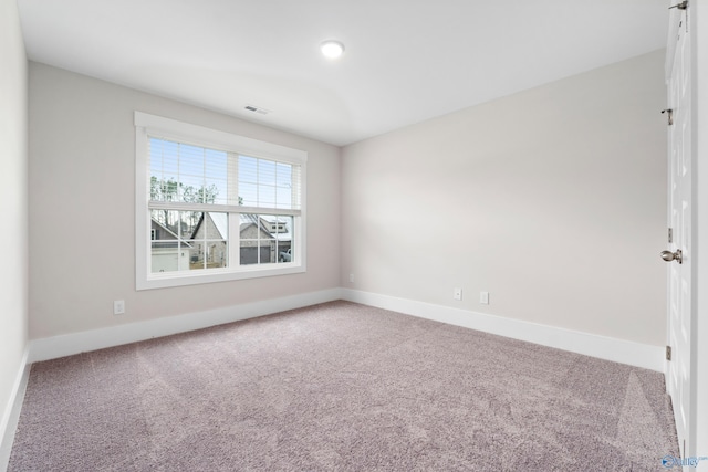 carpeted empty room featuring visible vents and baseboards