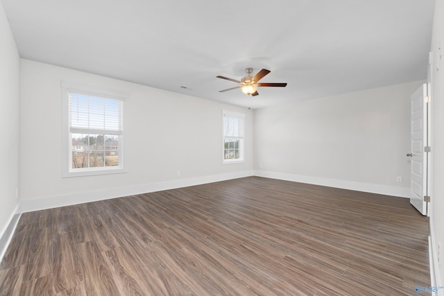 unfurnished room featuring ceiling fan, dark wood finished floors, and baseboards