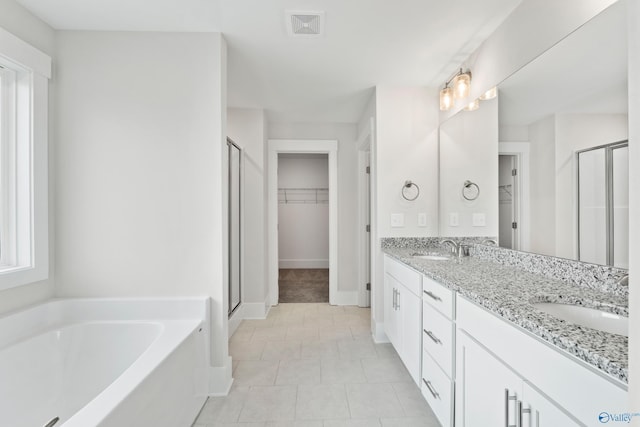 full bathroom featuring visible vents, a sink, a garden tub, and double vanity