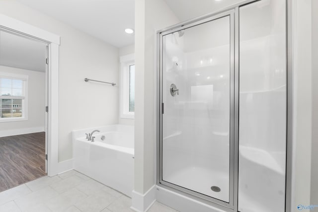 full bathroom with a stall shower, baseboards, a garden tub, and tile patterned floors