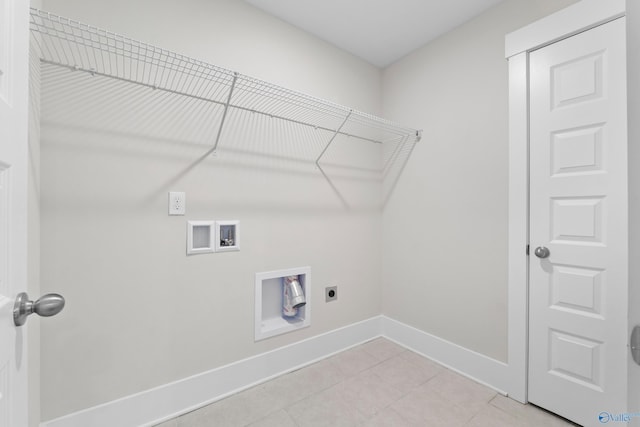 clothes washing area with light tile patterned flooring, hookup for a washing machine, hookup for an electric dryer, laundry area, and baseboards